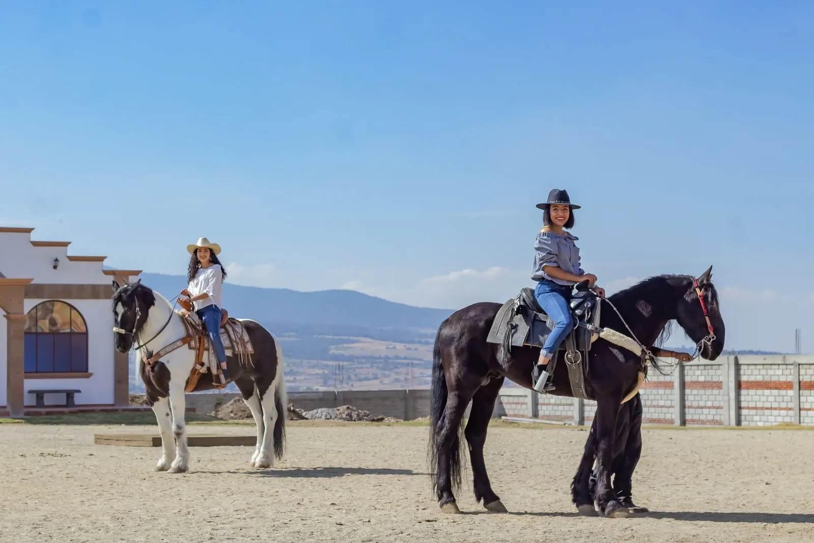 Two riders at the ranch on a sunny day